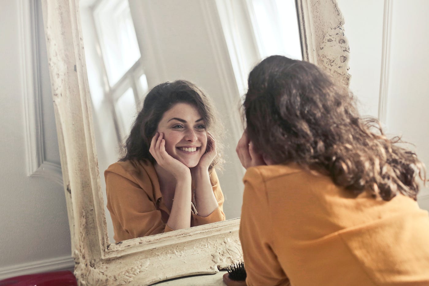 Woman looking into mirror and smiling