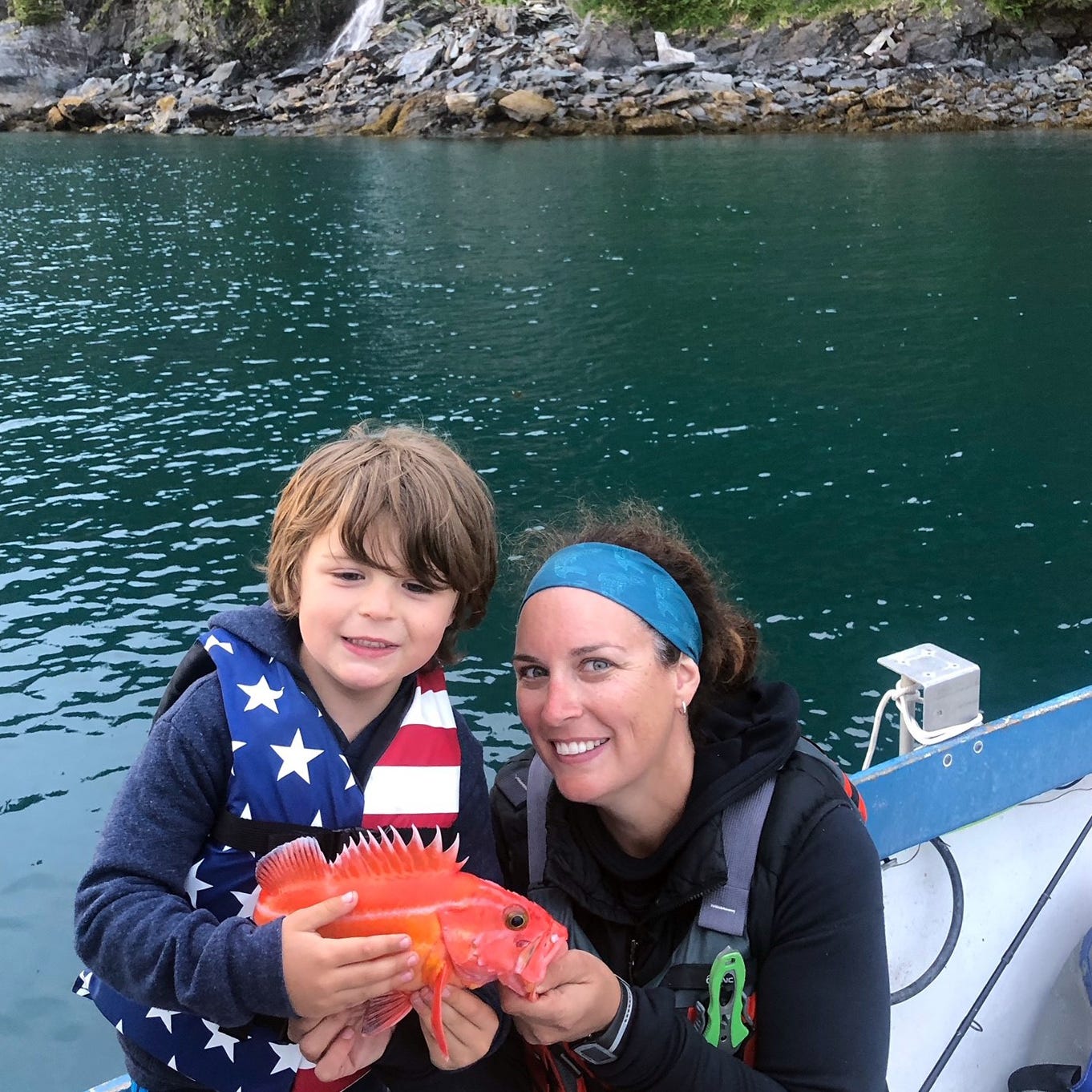 woman with a kid and juvenile yelloweye on a boat