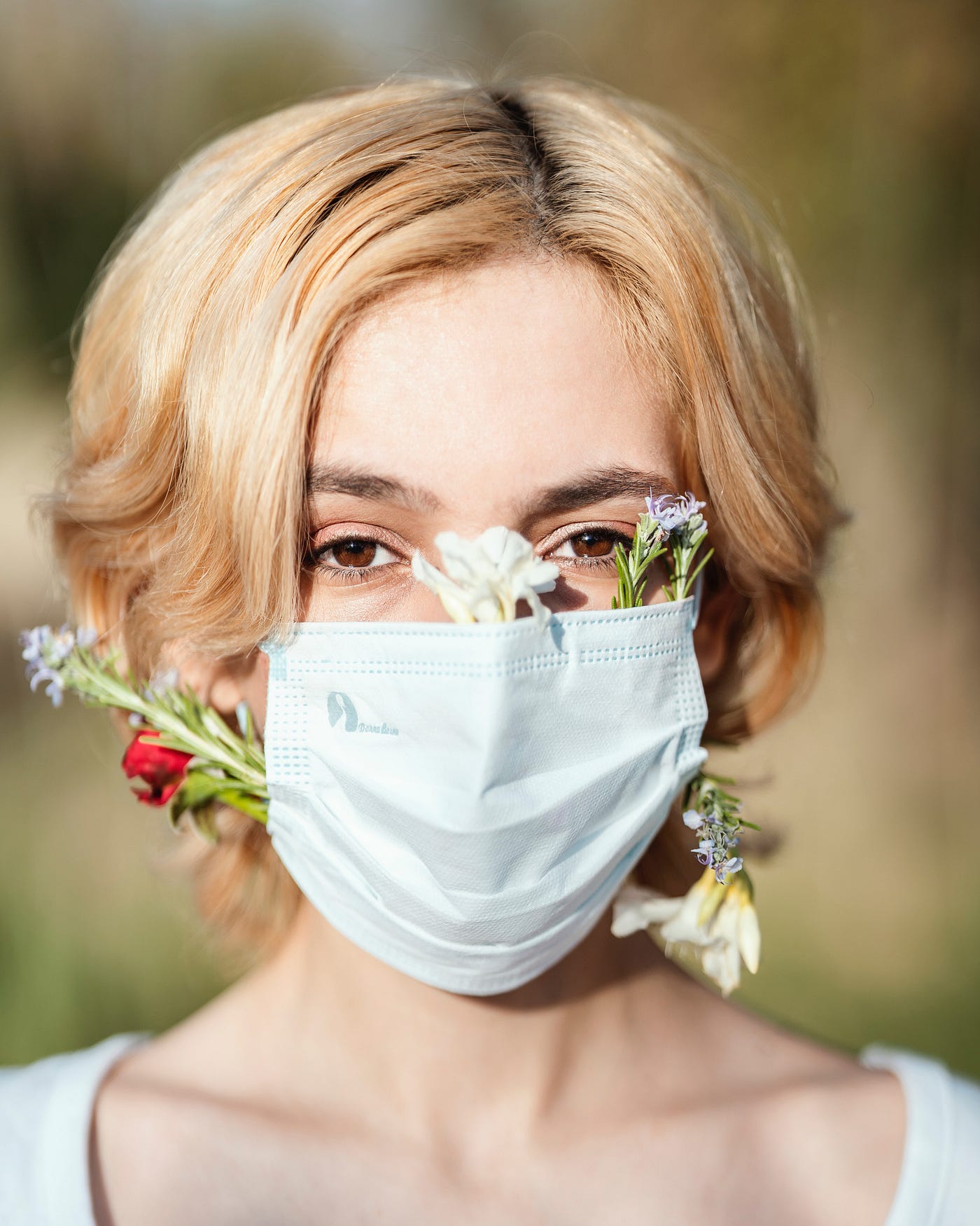 a woman wearing a mask with flowers sticking out