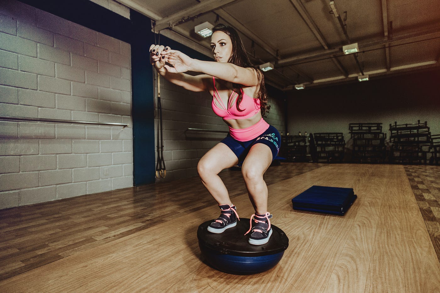 A women doing squat on balance ball.