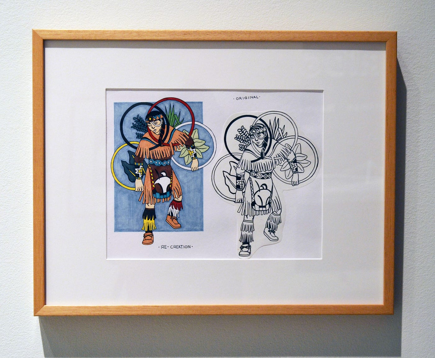 A photo frame featuring a drawing of two hoop dancers: the one on the left is in colour, and is dancing with yellow, black, red, and white hoops, and the one on the right is in black and white.