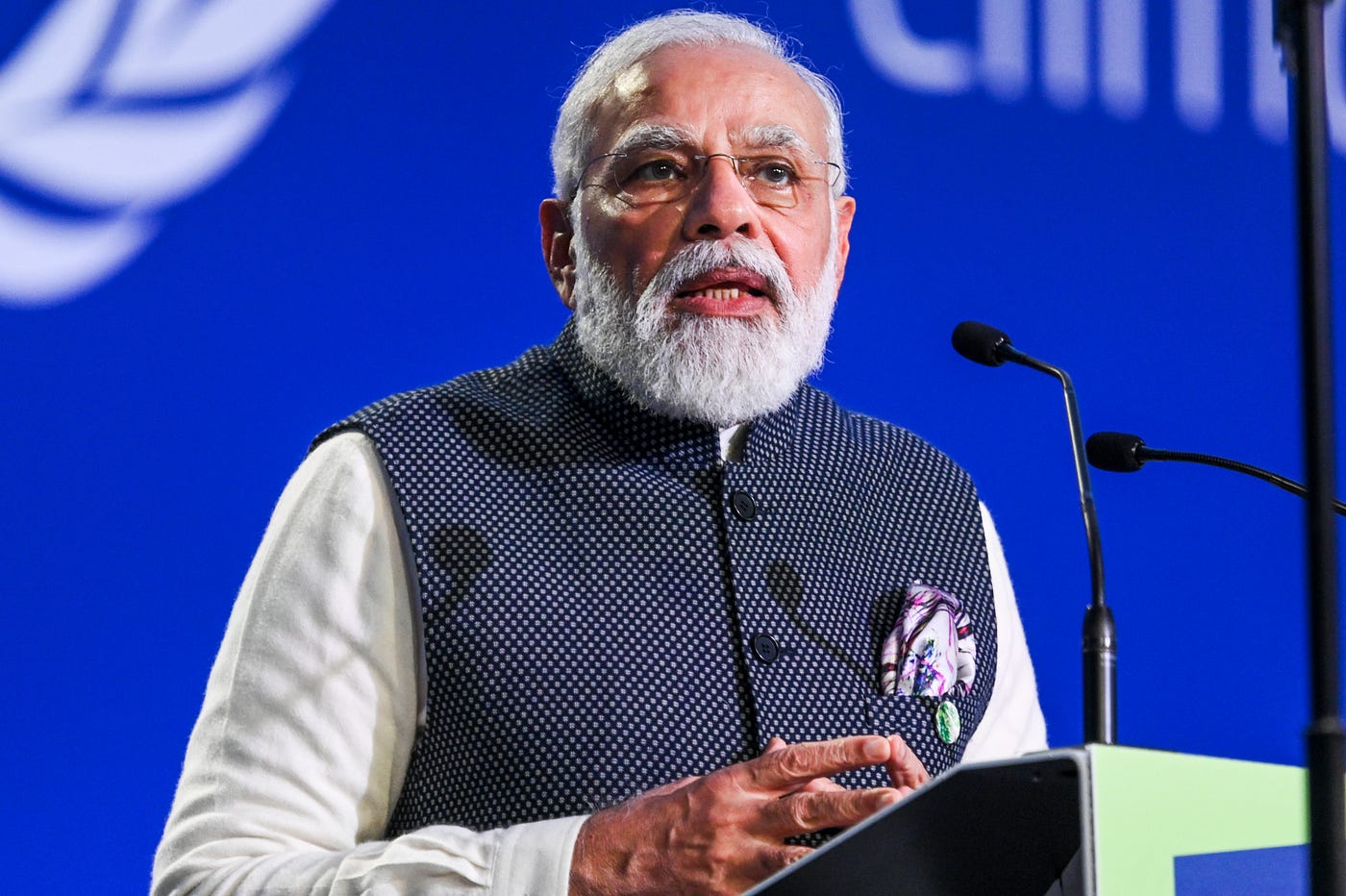 Indian Prime Minister Narendra Modi Stands at a podium and addresses the COP26 conference.