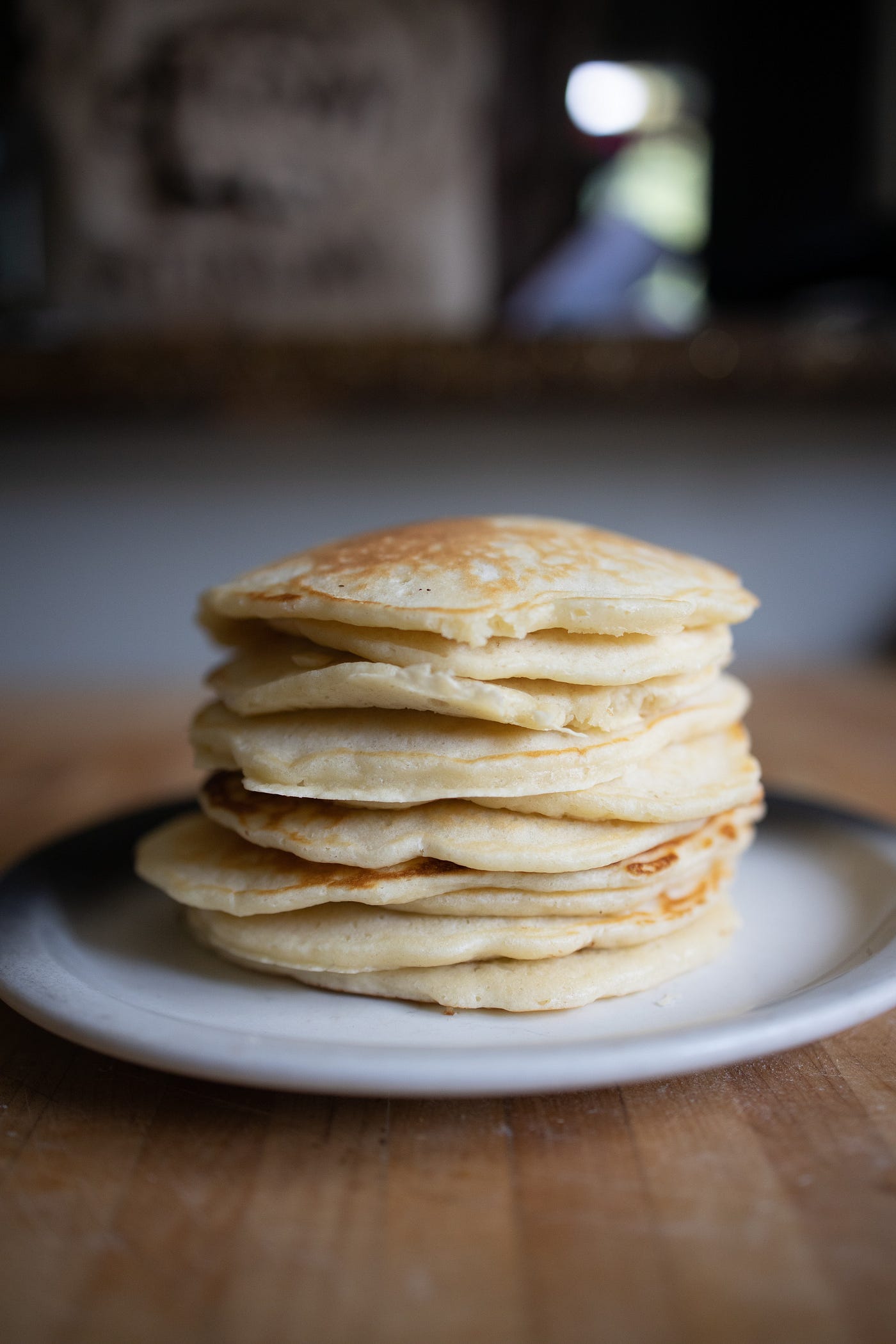 A stack of pancakes on a wooden countertop.