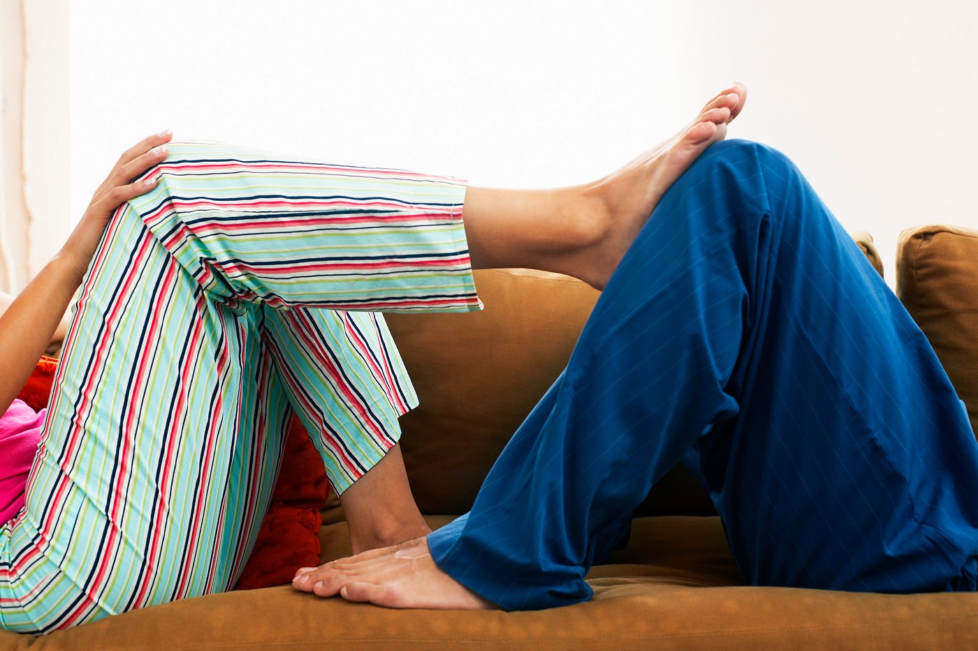 Photo of a couple lying on opposite sides of the couch.
