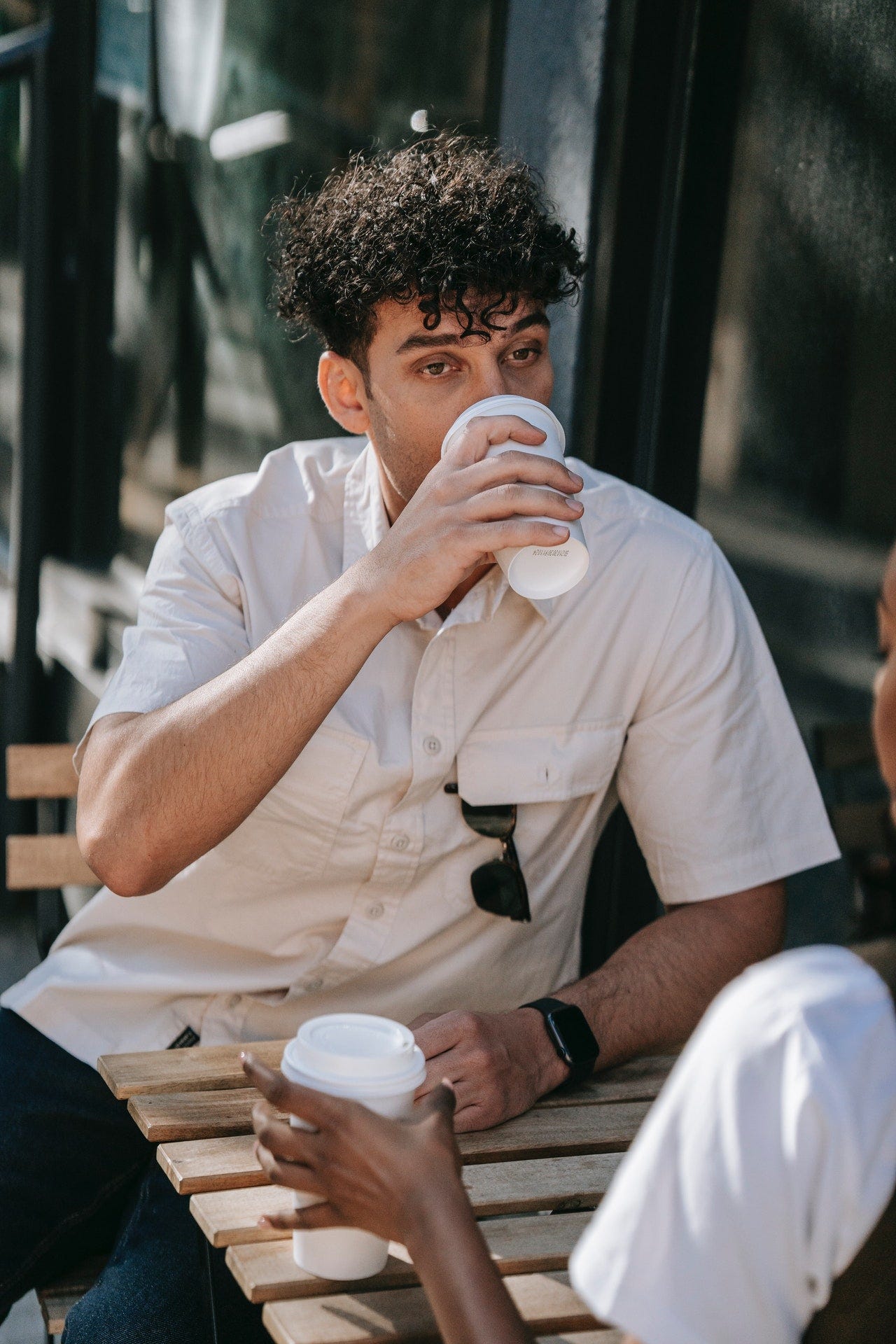 Man drinking from a styrofoam cup.