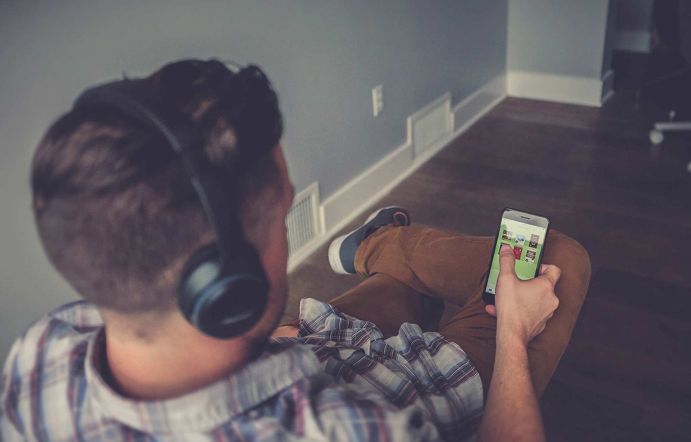 Man looking at iPhone consuming content.