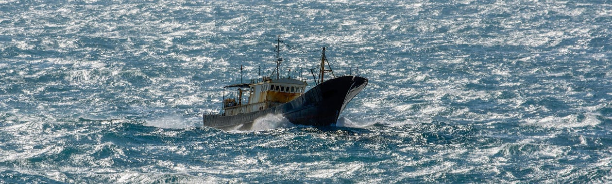 Small chinese trawler pounds through rough seas as it crosses the South China sea.