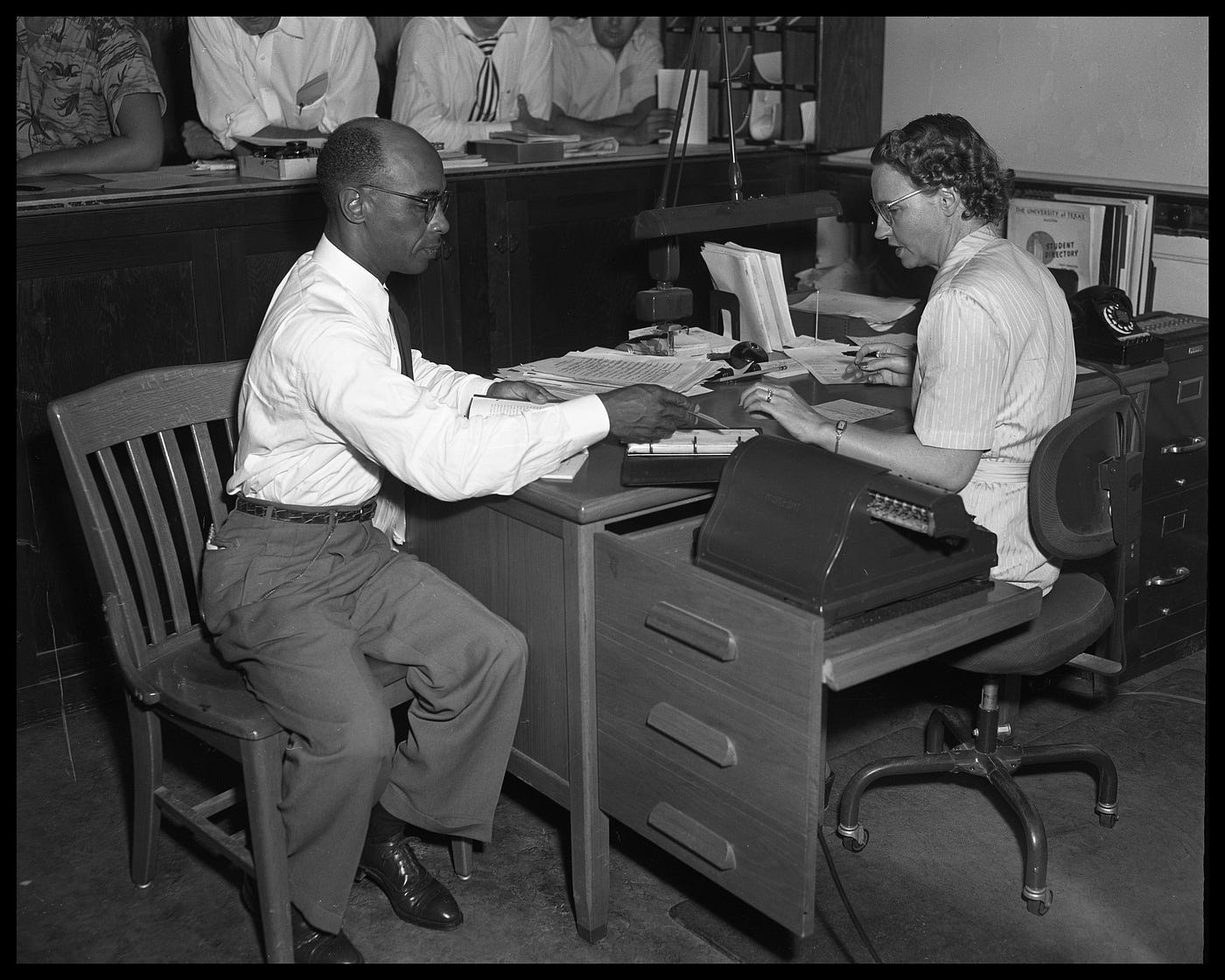 Herman Marrion Sweat works next to a woman at a desk.