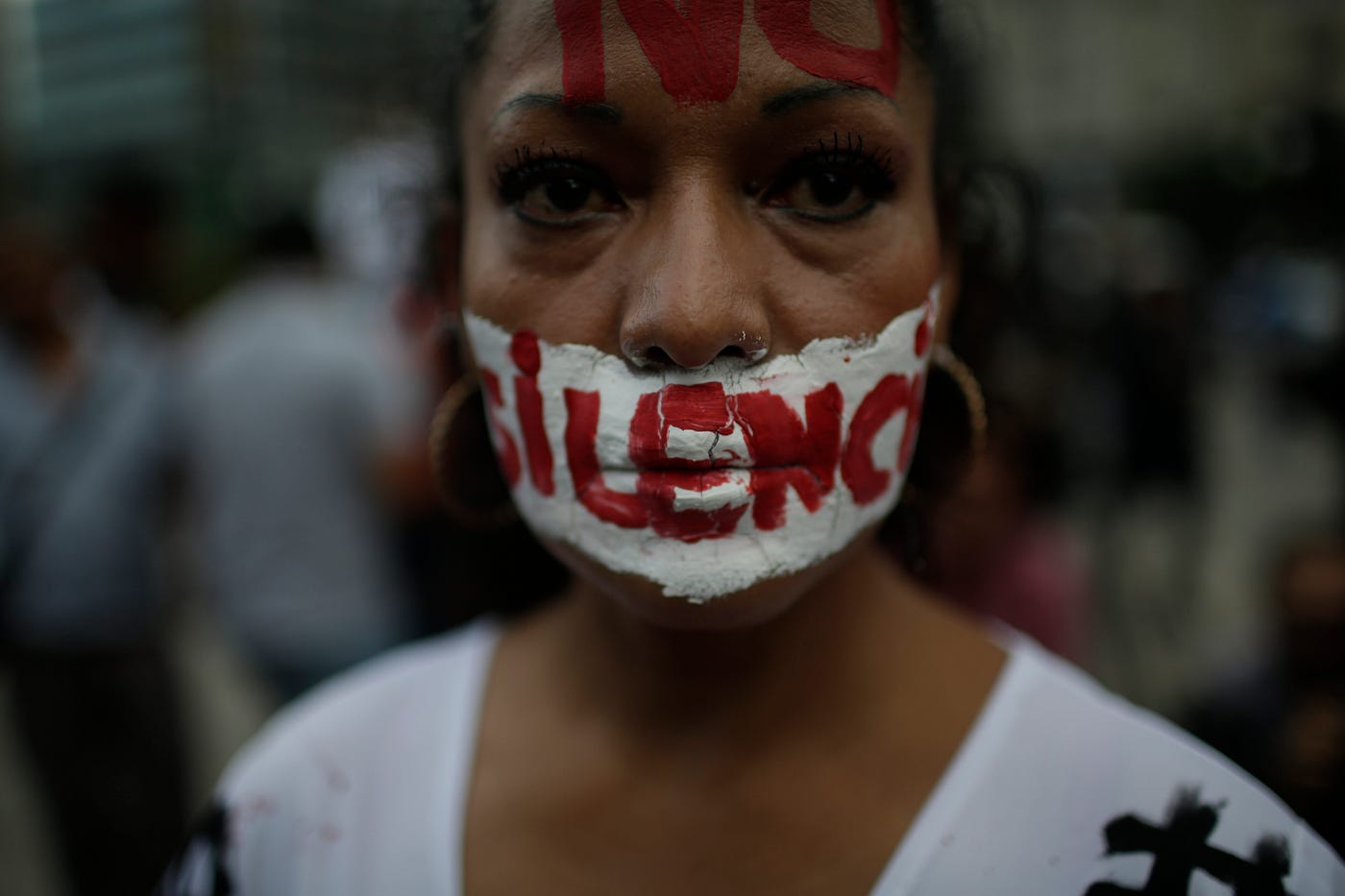 A woman with writing on her face that reads ‘no to silence’ looks at the camera during a demonstration in Mexico.