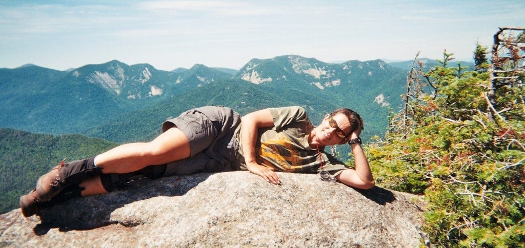 woman laying on a summit rock