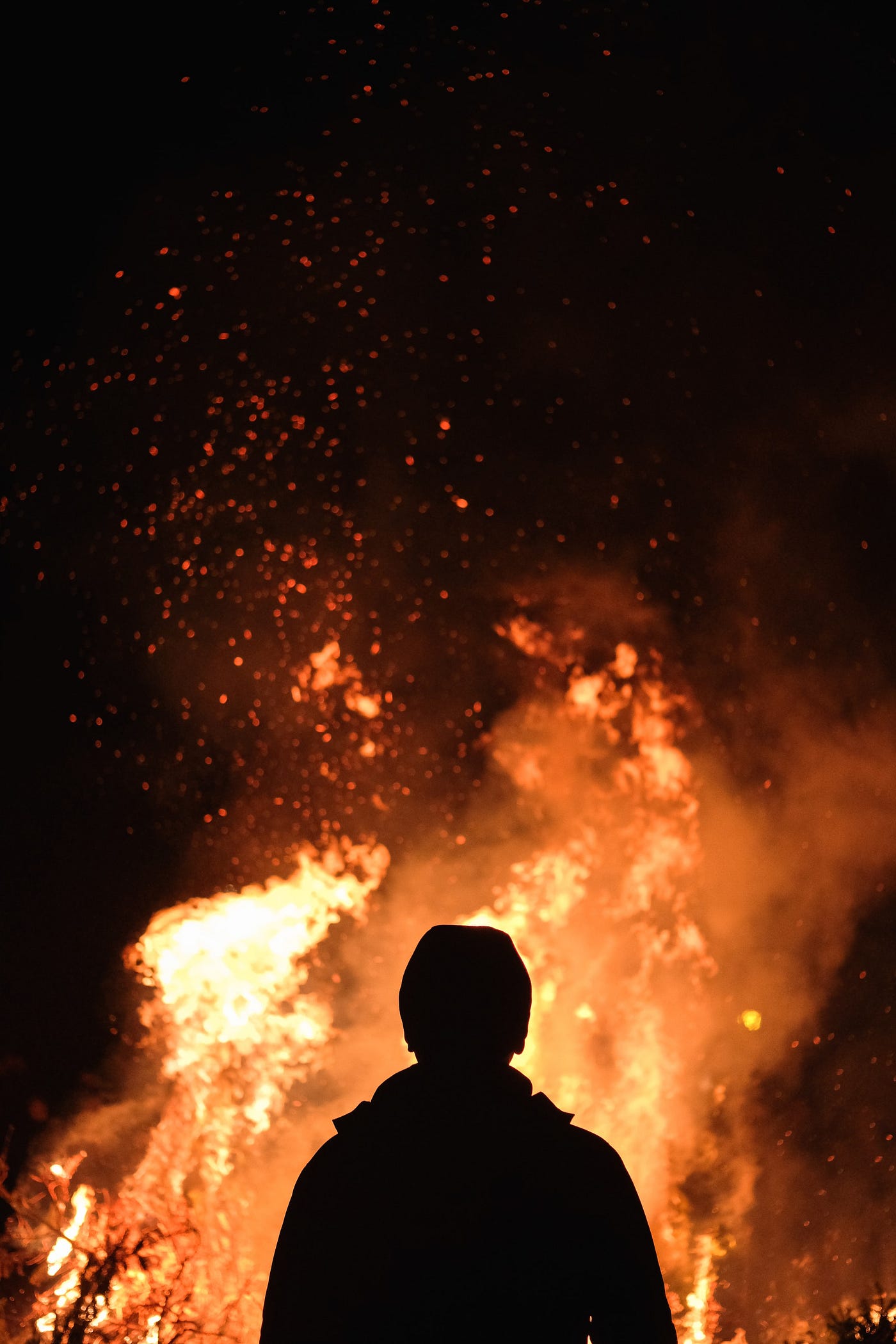 A person silhouetted by fire.