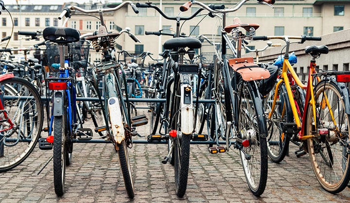 A row of colorful bikes lined up at a rack.