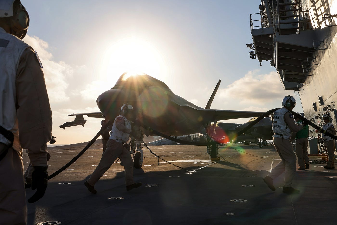 Military personnel prepare an F35B jet for a launch from HMS Queen Elizabeth.