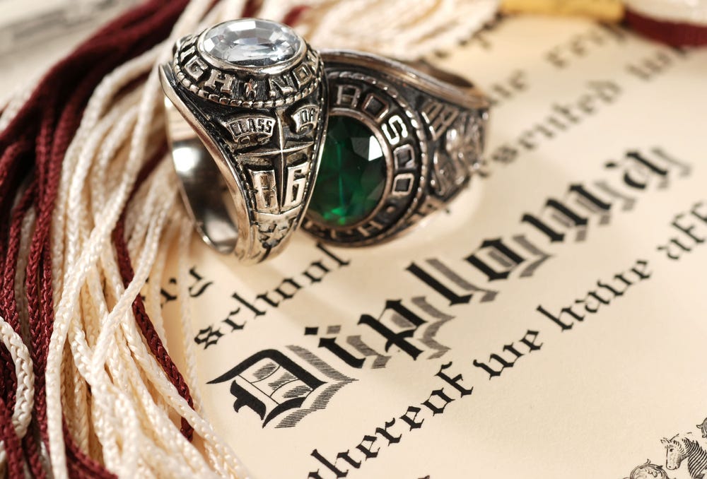Highschool diploma with two class rings: a young woman’s and a young man’s.