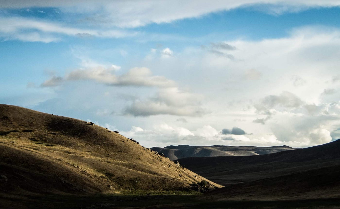 blue sky, white clouds, hills of brown in Mongolia