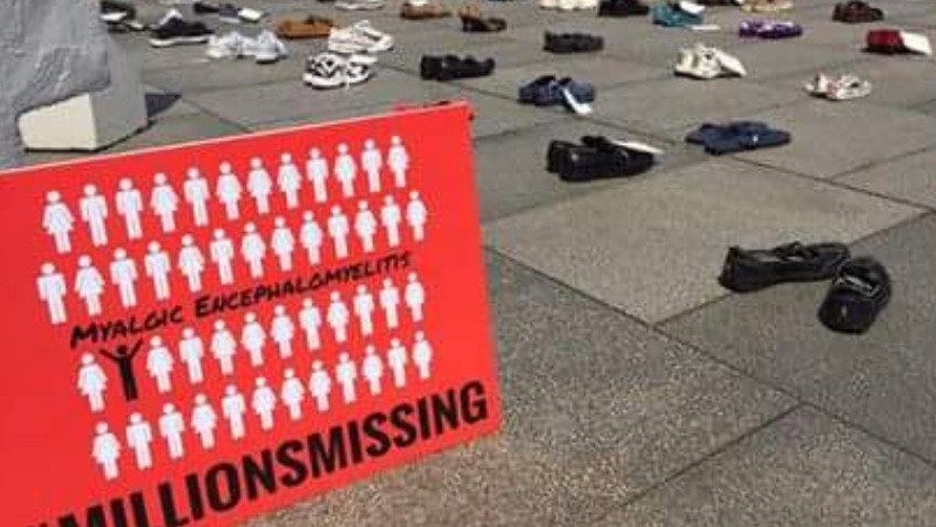 Empty shoes lined up on the groun, with a red Millions Missing poster alongside it