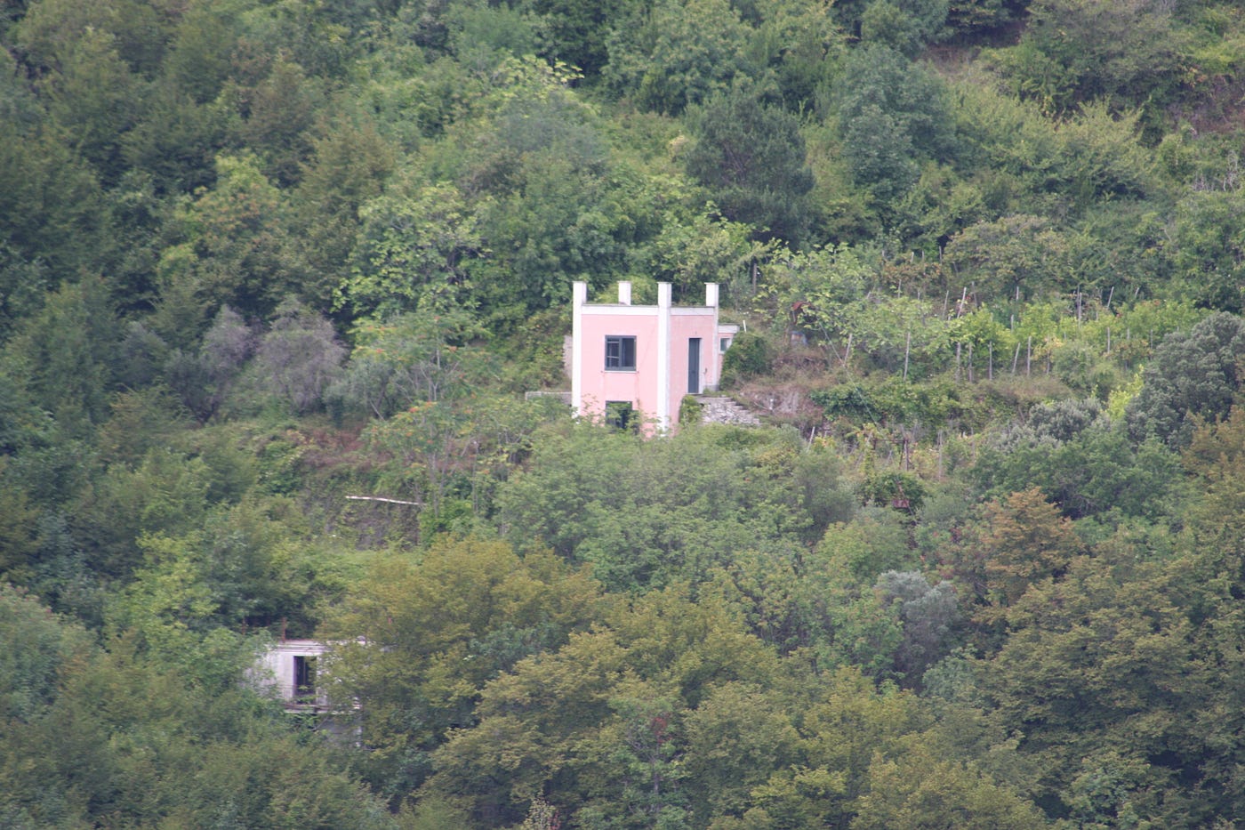 A small building nested on a hill surrounded by trees
