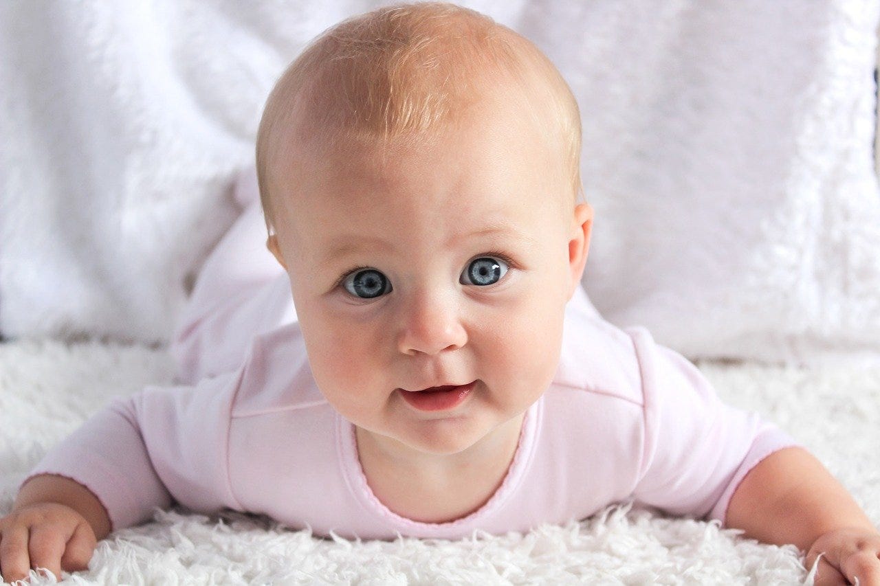 A baby on a white rug