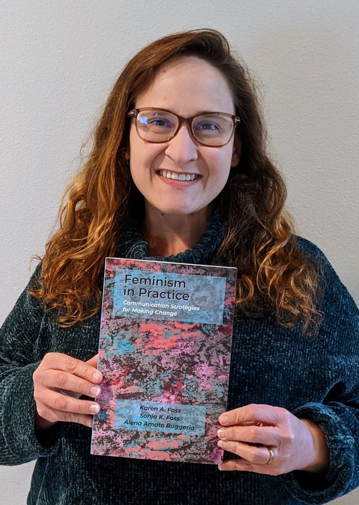 Photo of Alena Ruggerio holding her latest book