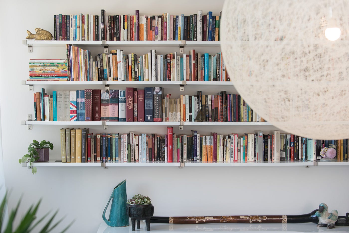 A dining room library combination with lots and lots of books.