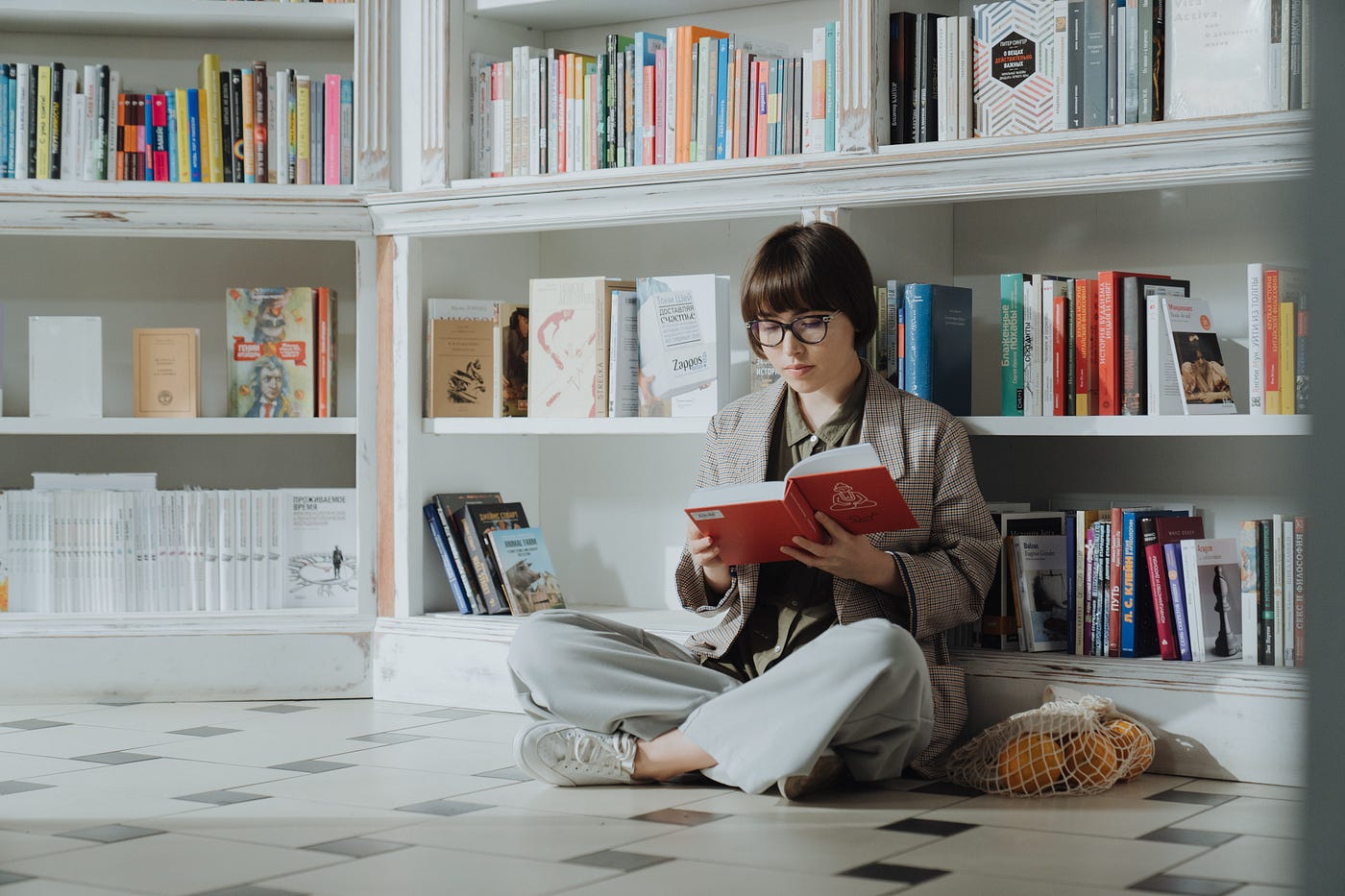 A woman in a gray long sleeve shirt reading a book