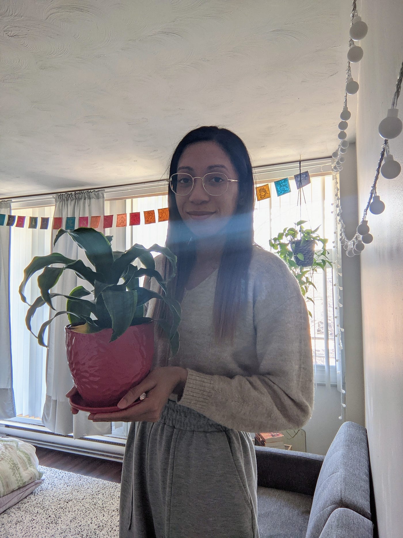 Photo of young woman holding a plant.