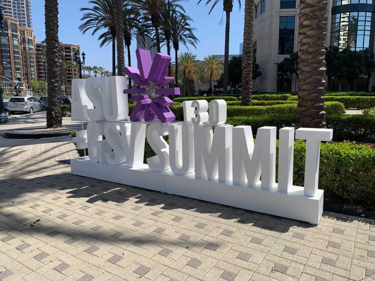 White 3-D lettering and purple sunburst logo spelling out ASU+GSV 13.0 Summit