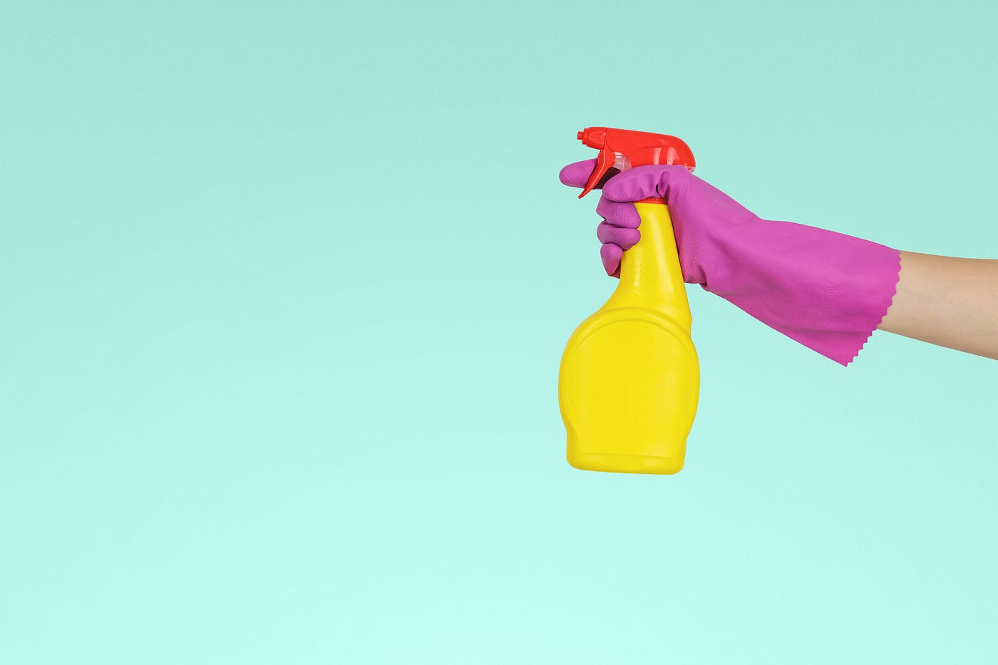A gloved hand holding a spray bottle.