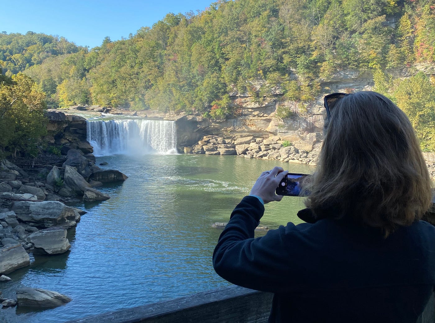 My wife taking a picture of a waterfall while we vacationed.