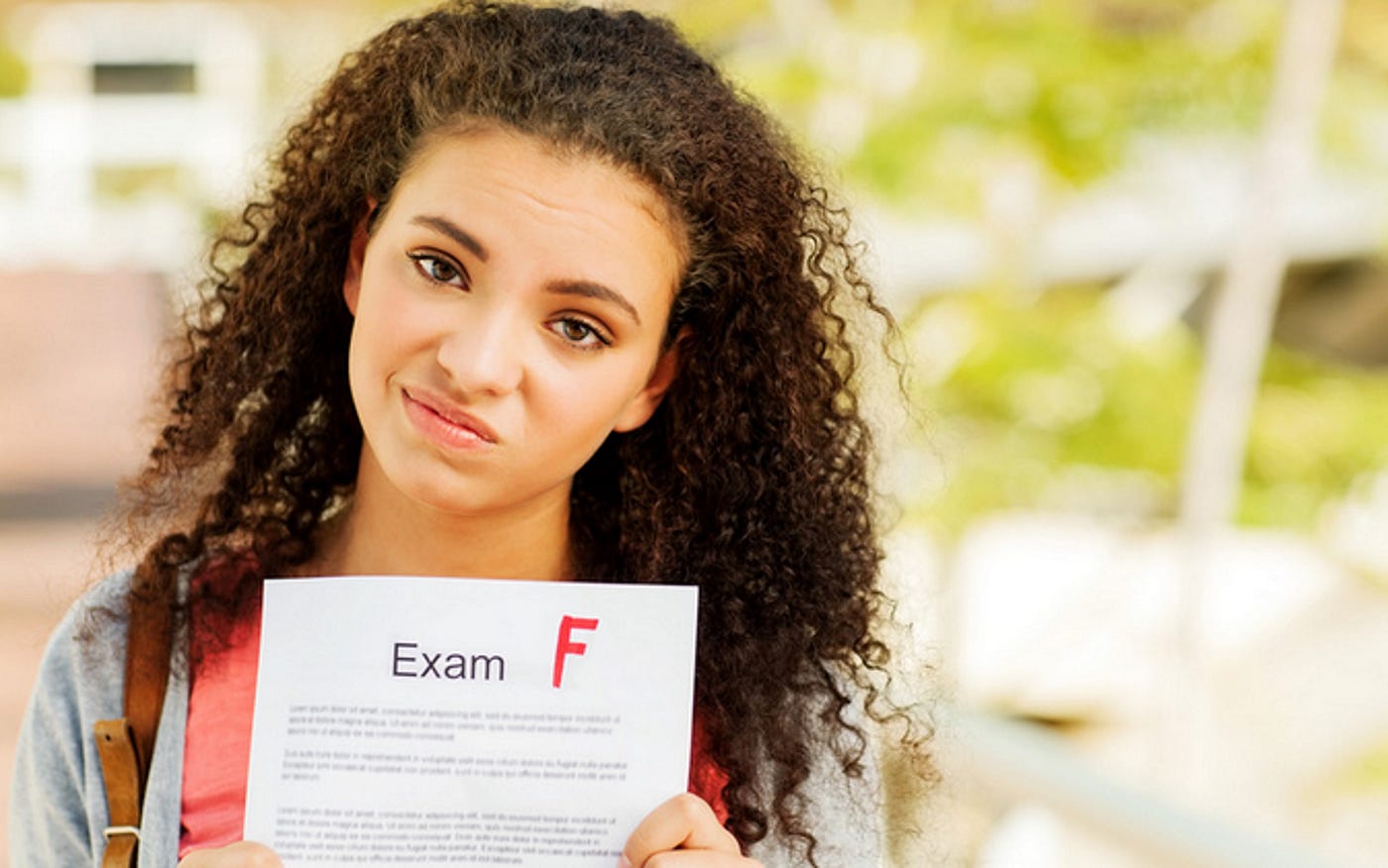 Girl holding paper with F score for failure