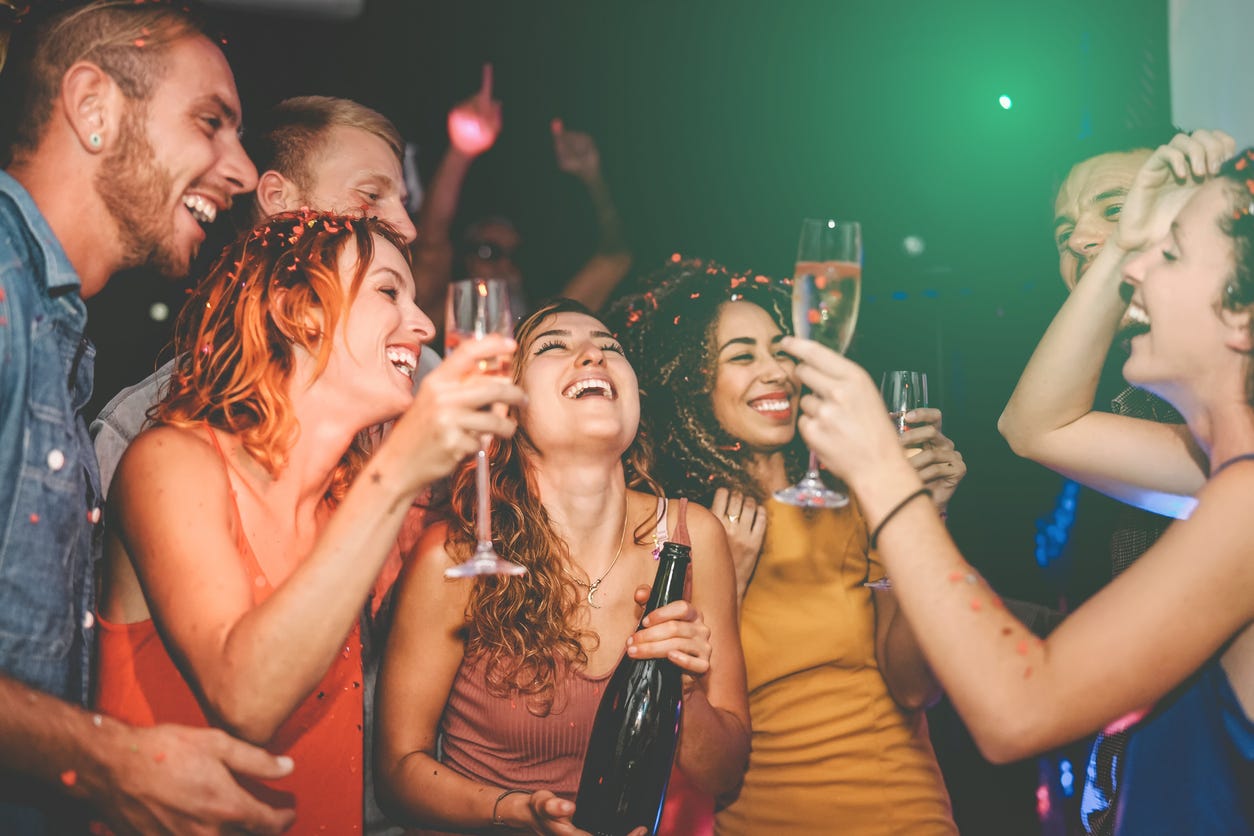 Happy friends doing party drinking champagne in nightclub wearing no masks