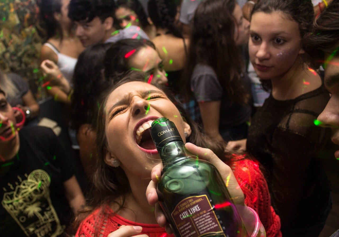 Woman being poured a drink from a bottle at a party