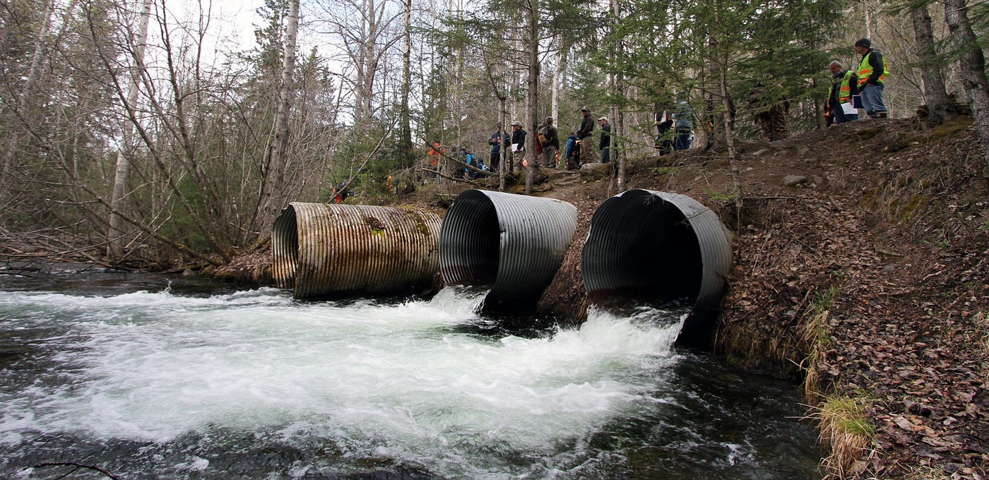 a stream pours out of 3 round culverts