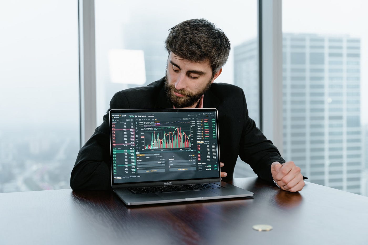 Man in Black Long Sleeve Shirt Showing a Computer Trading Stocks and Bitcoin.