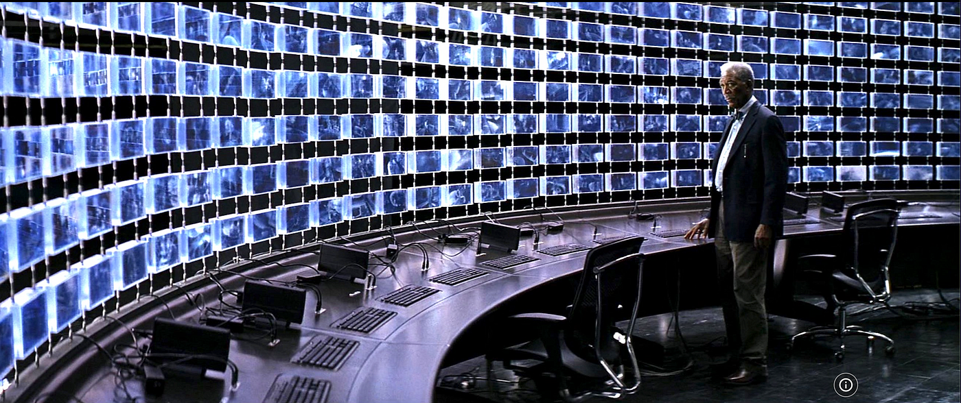 Morgan Freeman (the actor) stands in front of hundreds of screens in an intelligent operation center