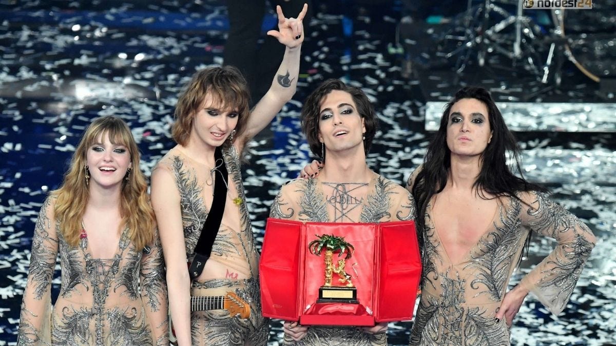 The rock group Manneskin, wearing see-through costumes, hold Golden Lion Award after winning 2021 Sanremo Musical Festival with their song “Zitti e Buoni.”
