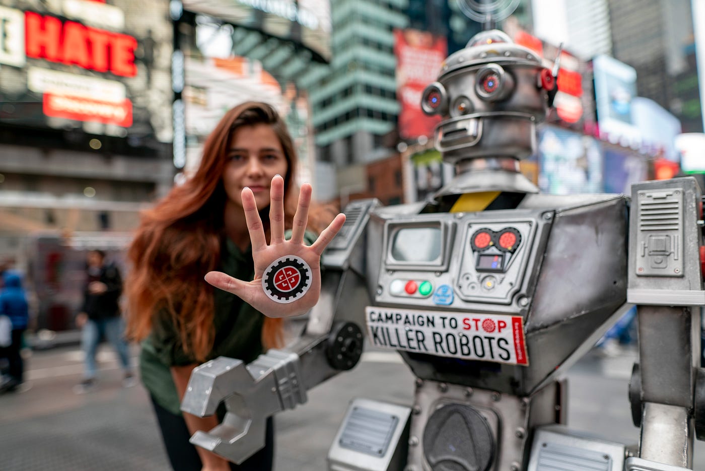 Marta Kosmyna and the Campaign’s robot in Time’s Square. Marta holds her palm to the camera with the Campaign’s avatar on it.