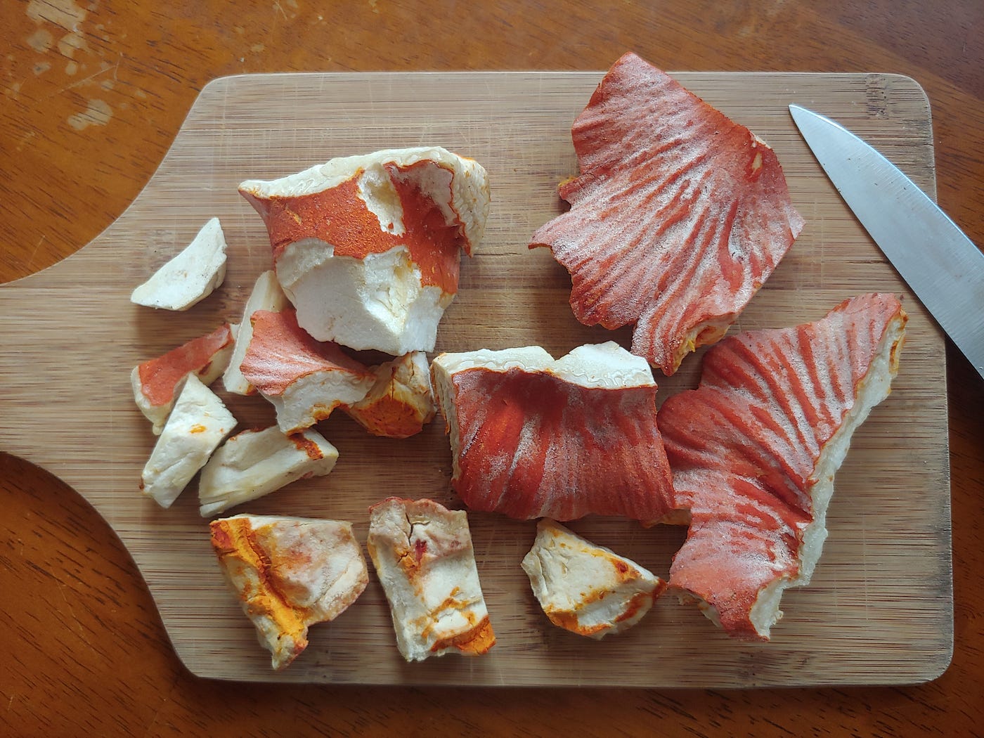 Cleaned lobster mushroom chunks on a cutting board ready for slicing