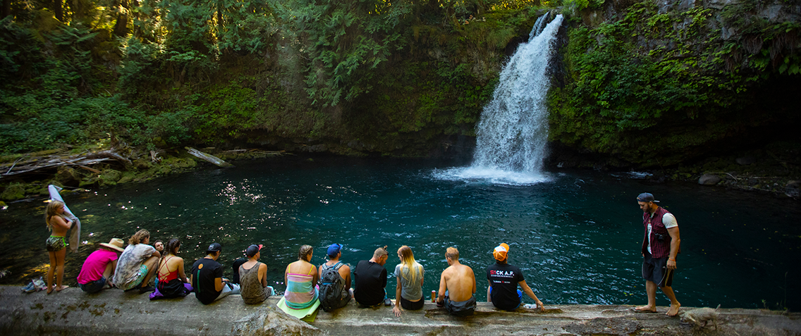 A group of friends who love to adventure together outdoors enjoying a waterfall experience.
