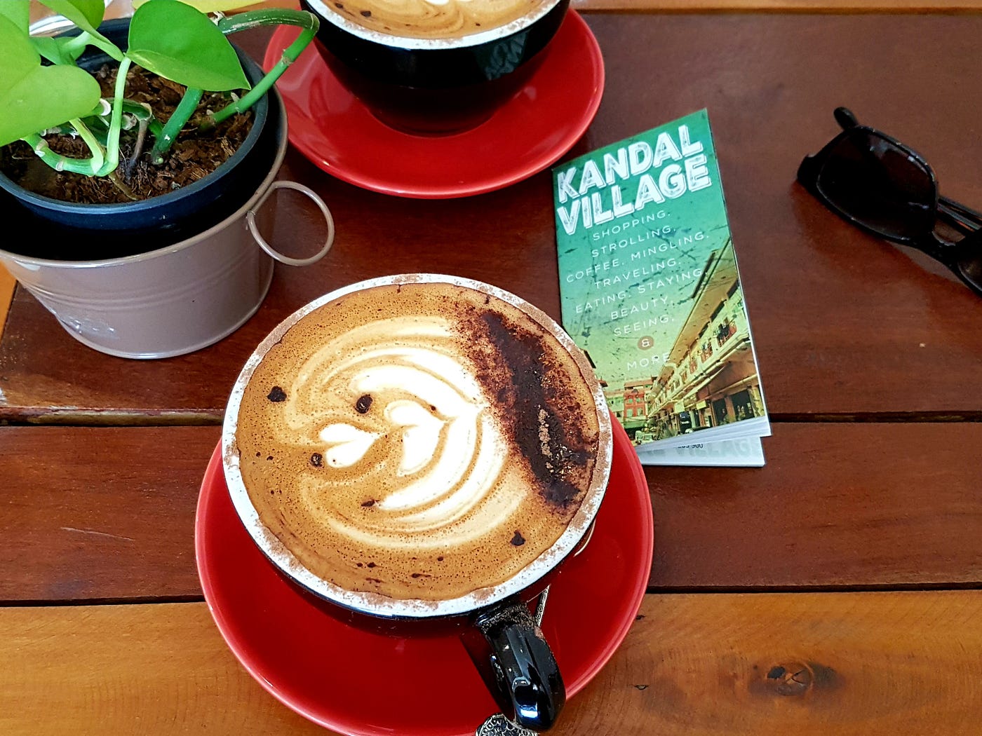 Photo of cappuccino with Kandal Village brochure