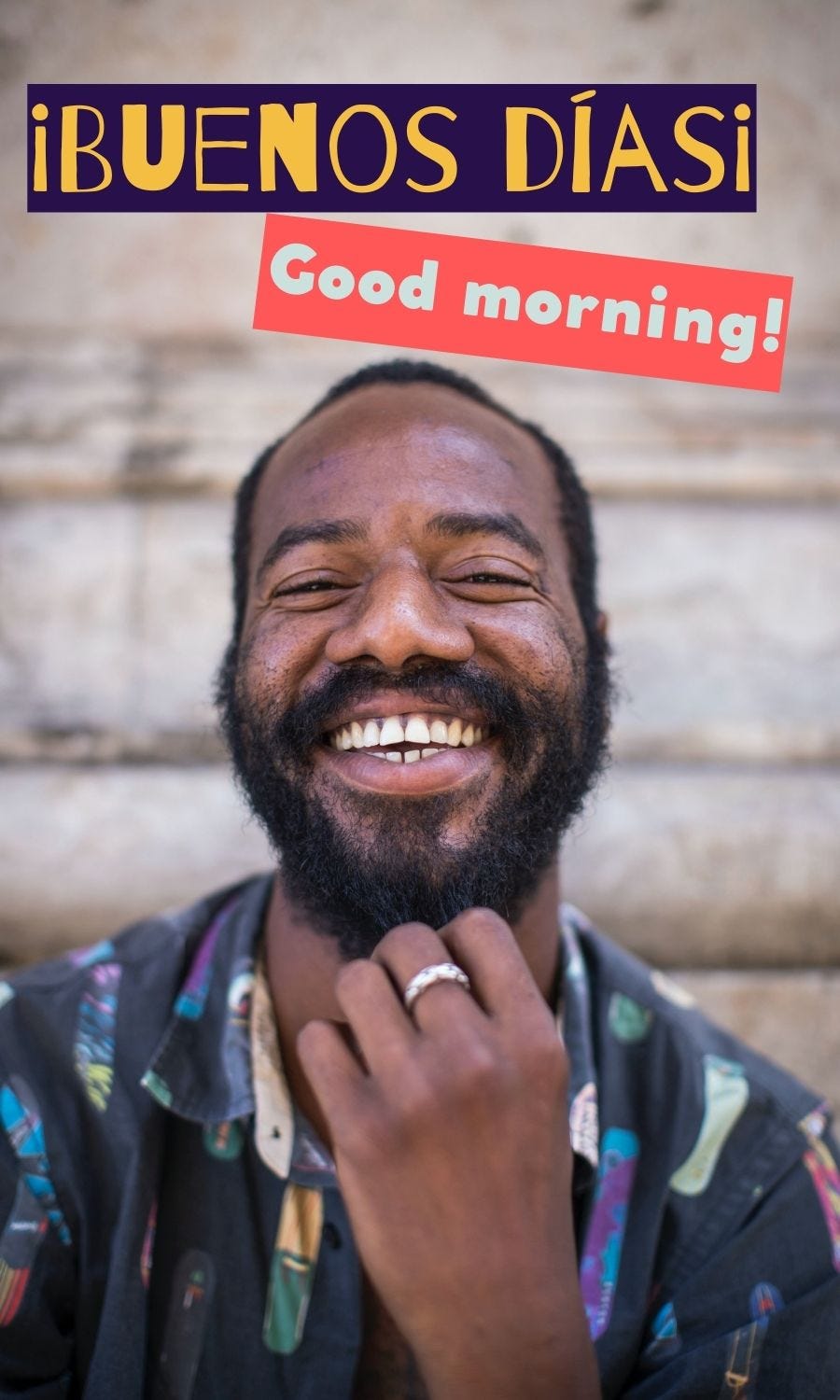 Black man smiling with words buenos dias and good morning