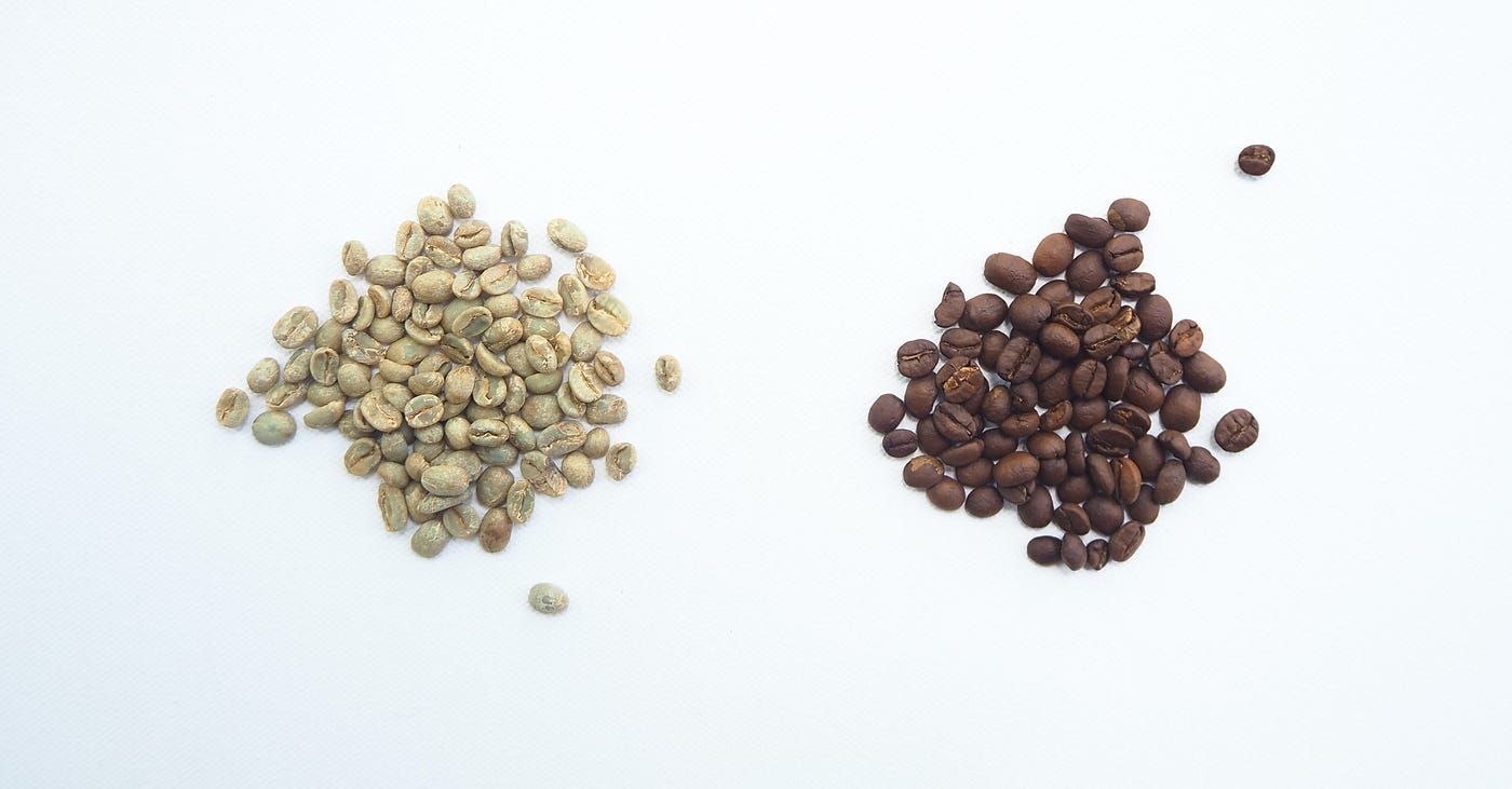Two piles of coffee beans, one green and one brown