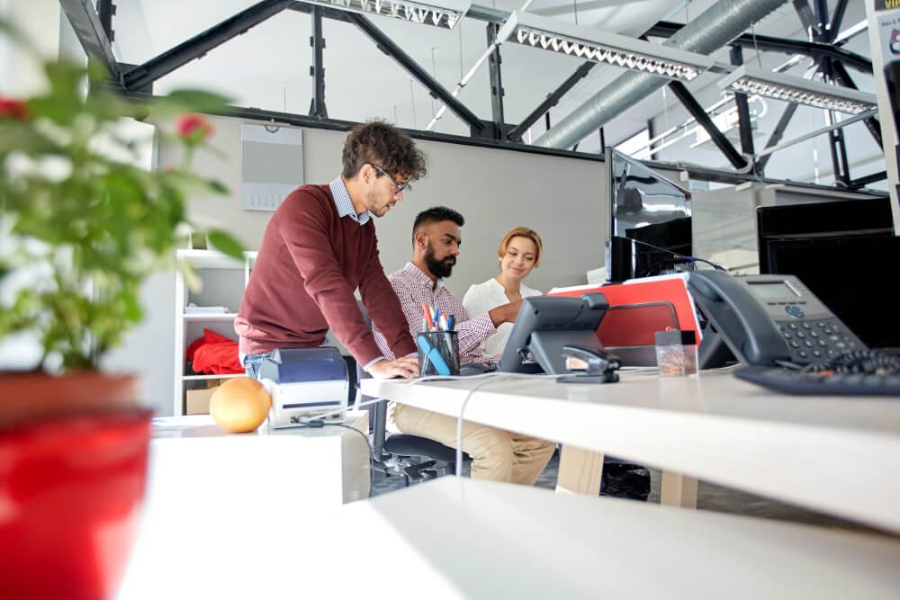 Team members working together in front of a computer.