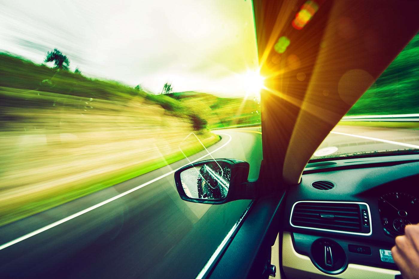Close-up of car side mirror, racing down the road, sun in the foreground, fantasy-style lighting