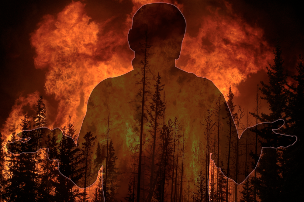 A silhouette of a shrugging man in front of a wildfire.