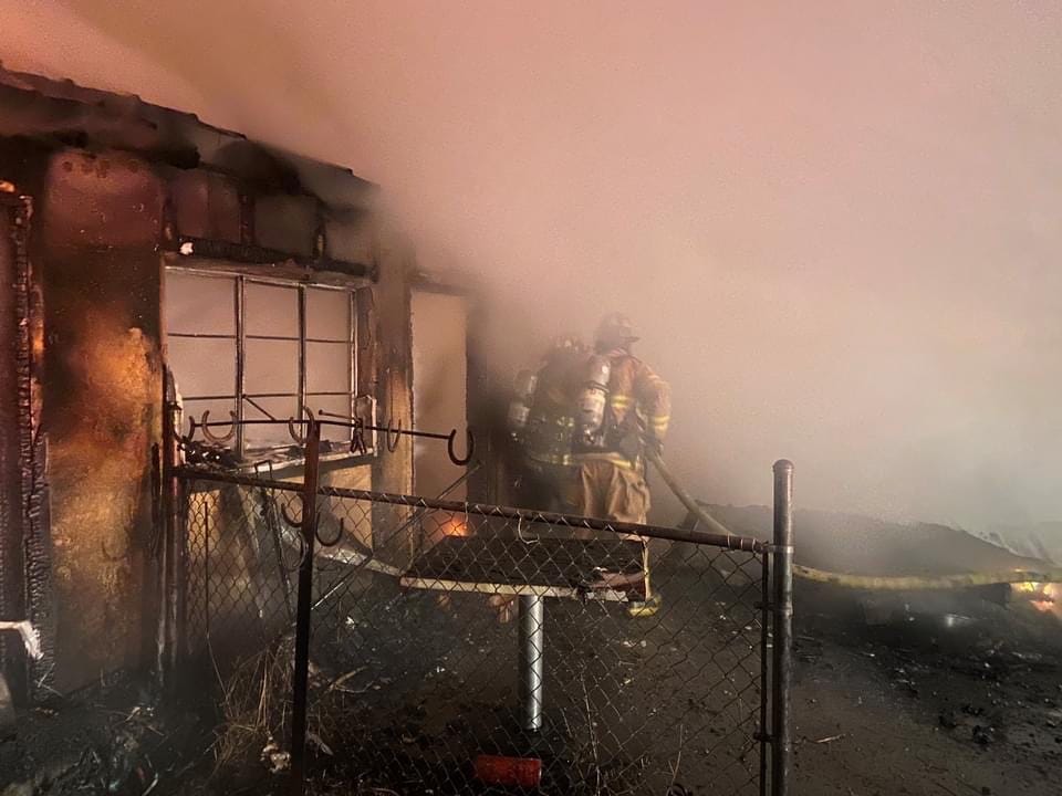 Completely burned house with fireman