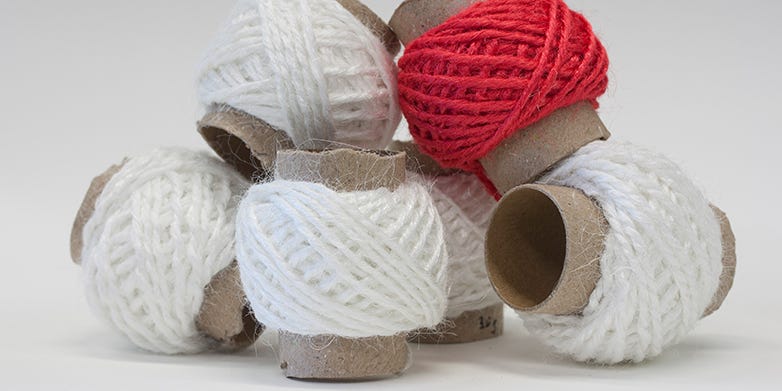 White and red spools of gelatin yarn on toilet paper rolls