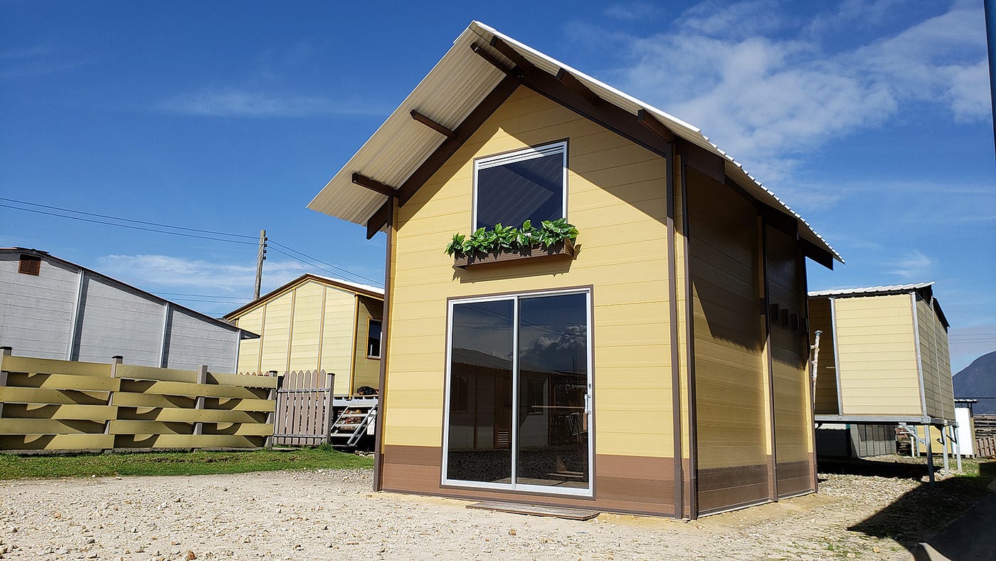 beige tiny home with gabled roof