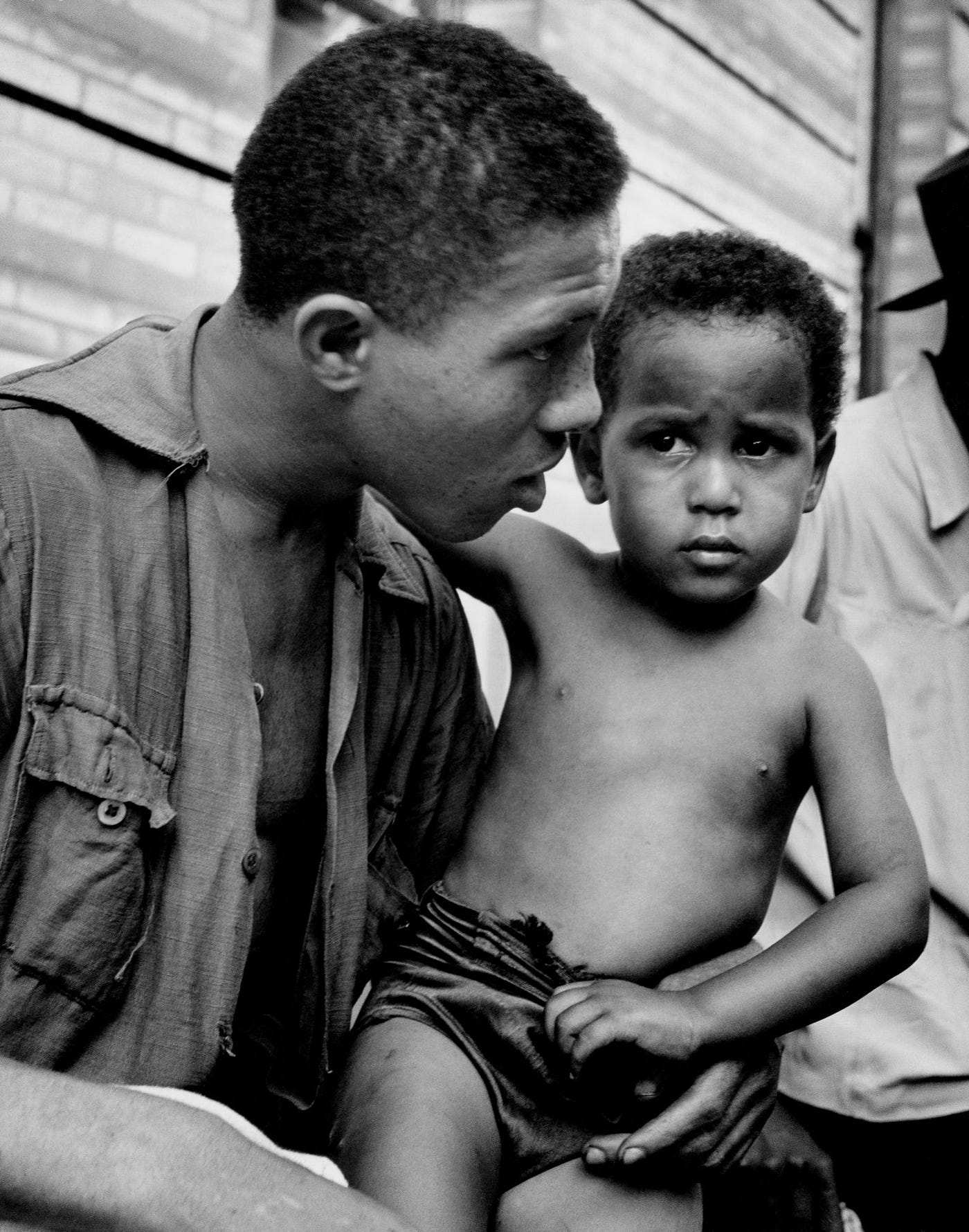 Harlem gang leader, Red Jackson with a child on his lap