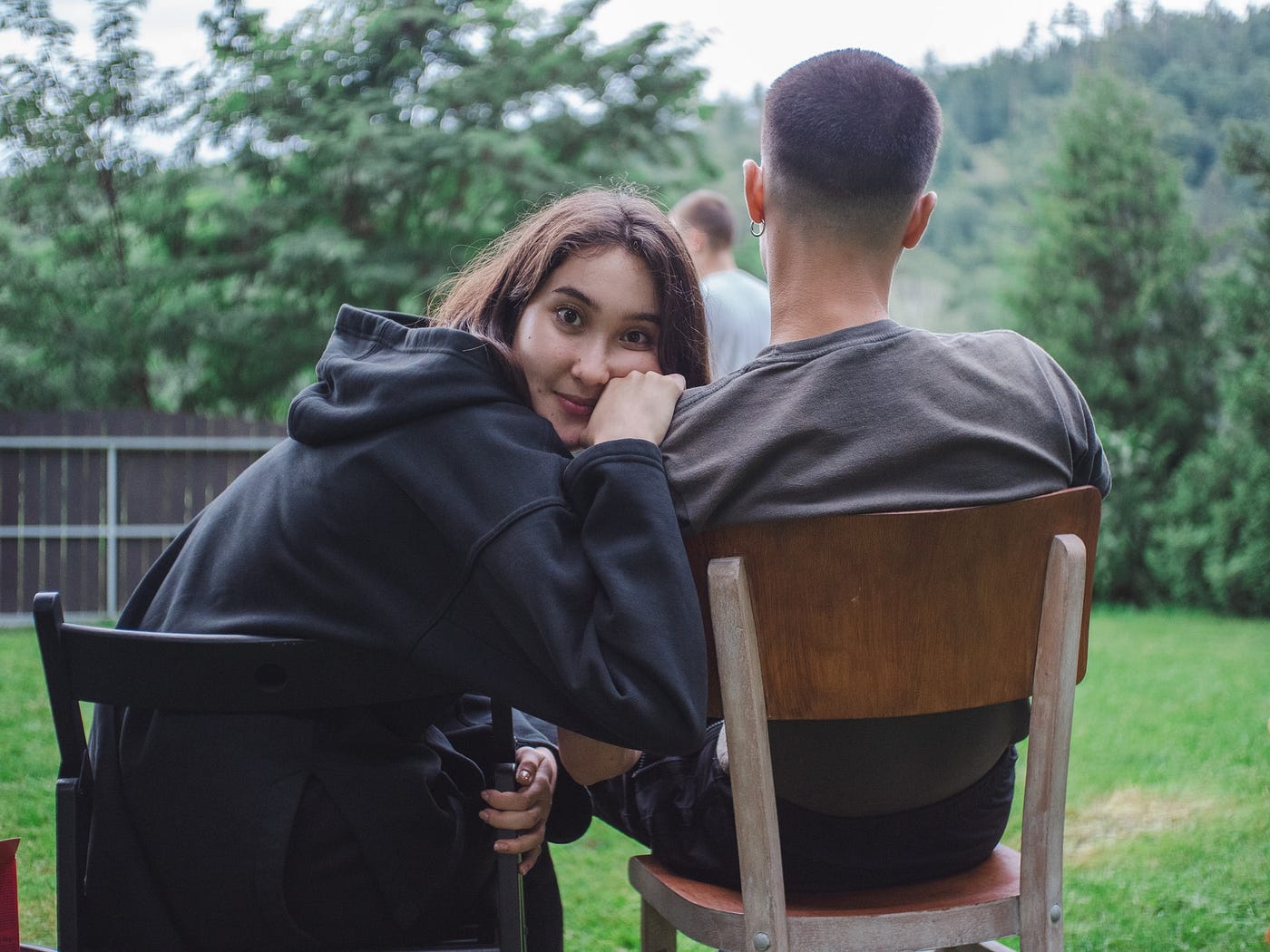 self-actualisation girl sitting back yard looking back from boyfriend shoulder thinking smiling
